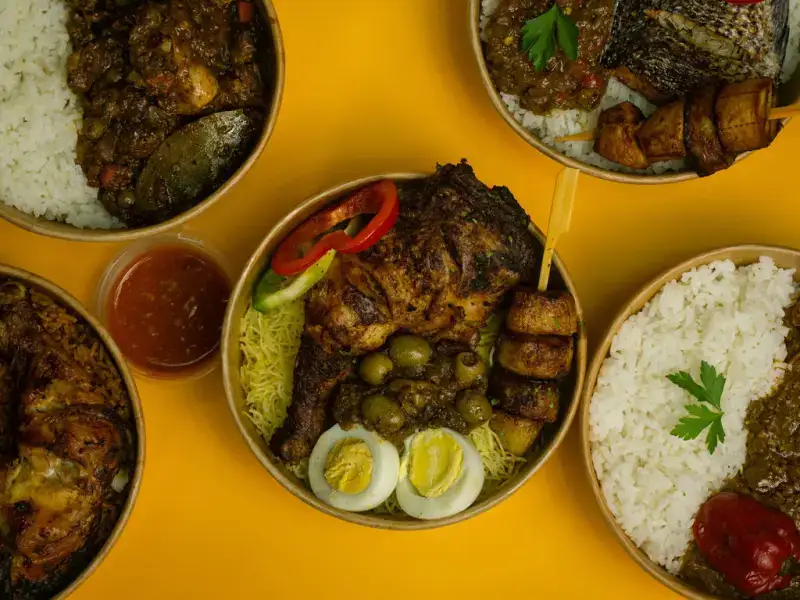 Overhead spread of four rice and stew bowls arranged together on a bright yellow backdrop